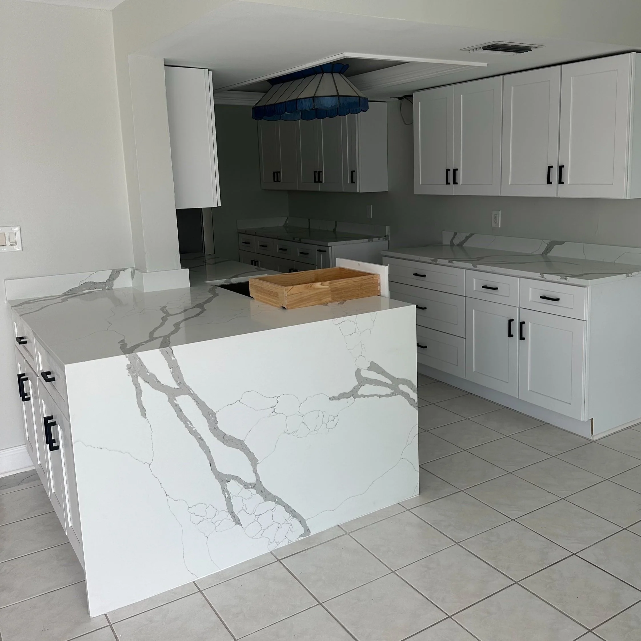 White kitchen with marble waterfall island and shaker cabinets